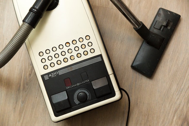 black vacuum cleaner on brown wooden surface